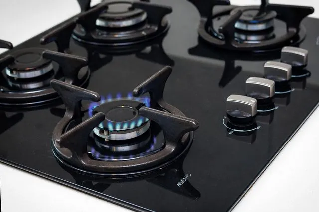 Modern gas cooktop with a lit burner during an appliance inspection